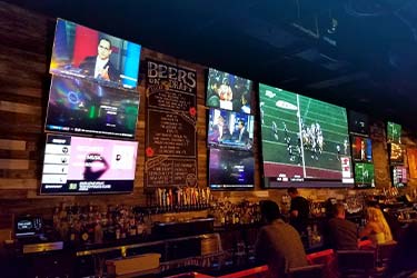 Wall of TVs at restaurant and bar that has HDMI switch multiplexors installed by 850 Pro